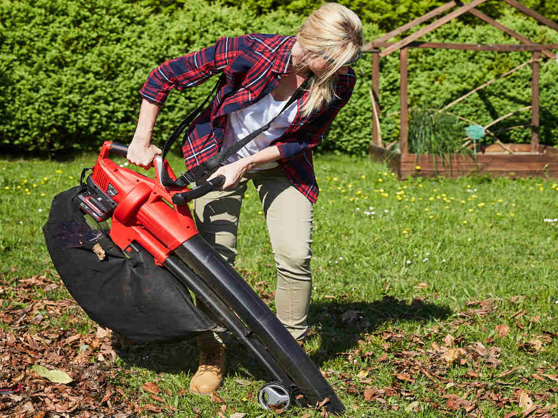 A woman using an Einhell leaf blower